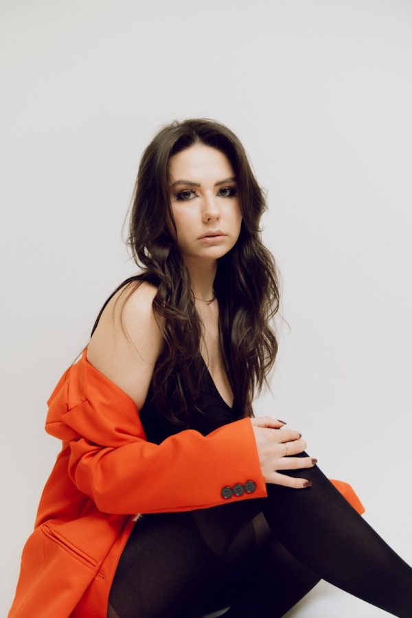 Elegant portrait of a woman in a red jacket on a white background.